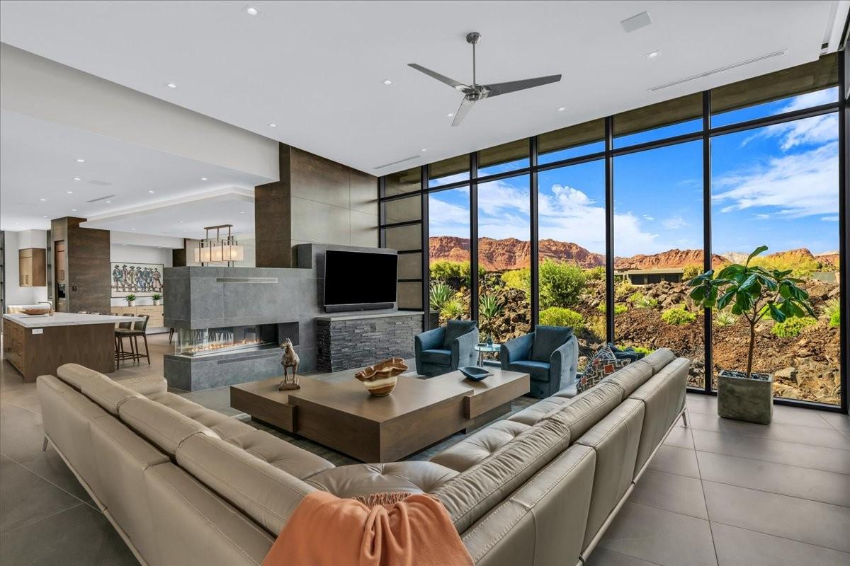 Expansive living area featuring floor-to-ceiling windows, a linear gas fireplace, and large format tile flooring