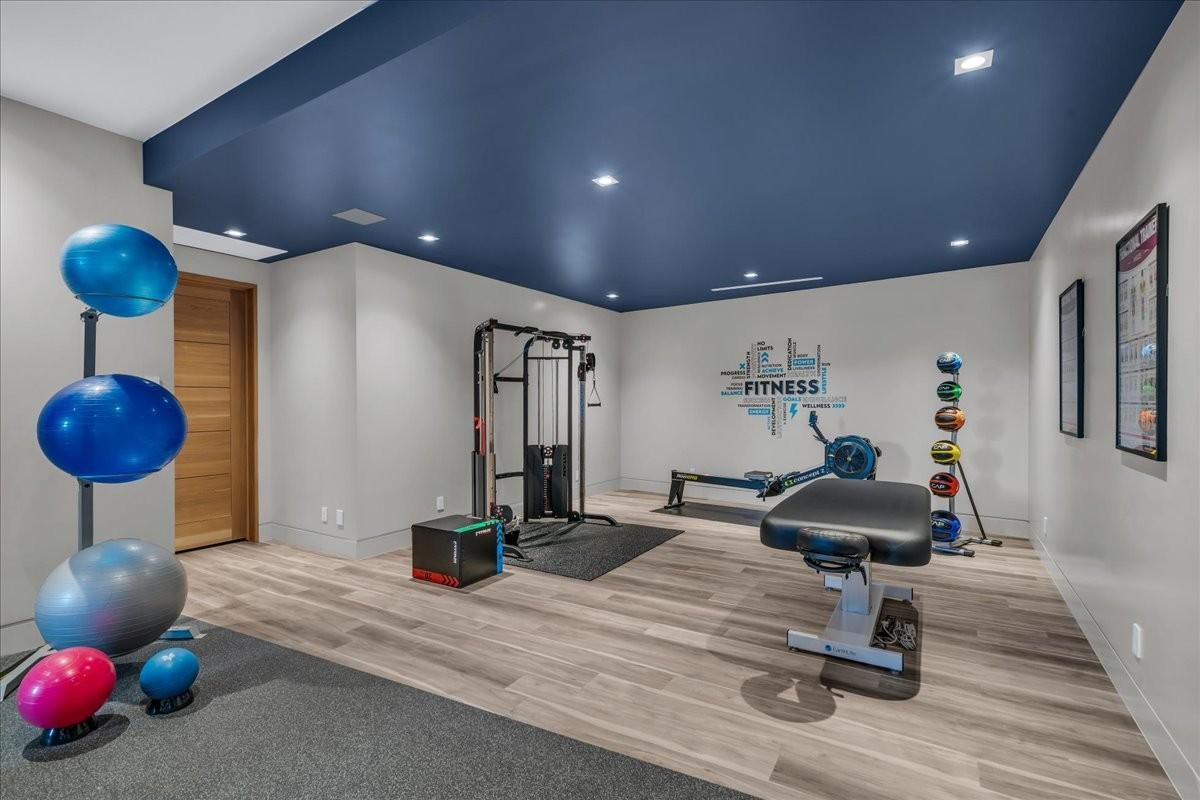 Dedicated fitness room featuring a deep blue accent ceiling with recessed lighting