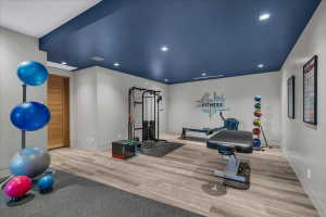 Dedicated fitness room featuring a deep blue accent ceiling with recessed lighting