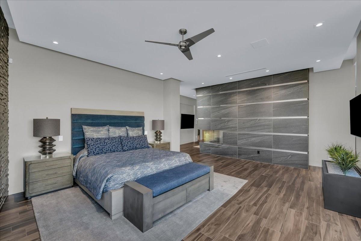 Spacious room featuring wood-finish flooring, a contemporary ceiling fan, and recessed lighting