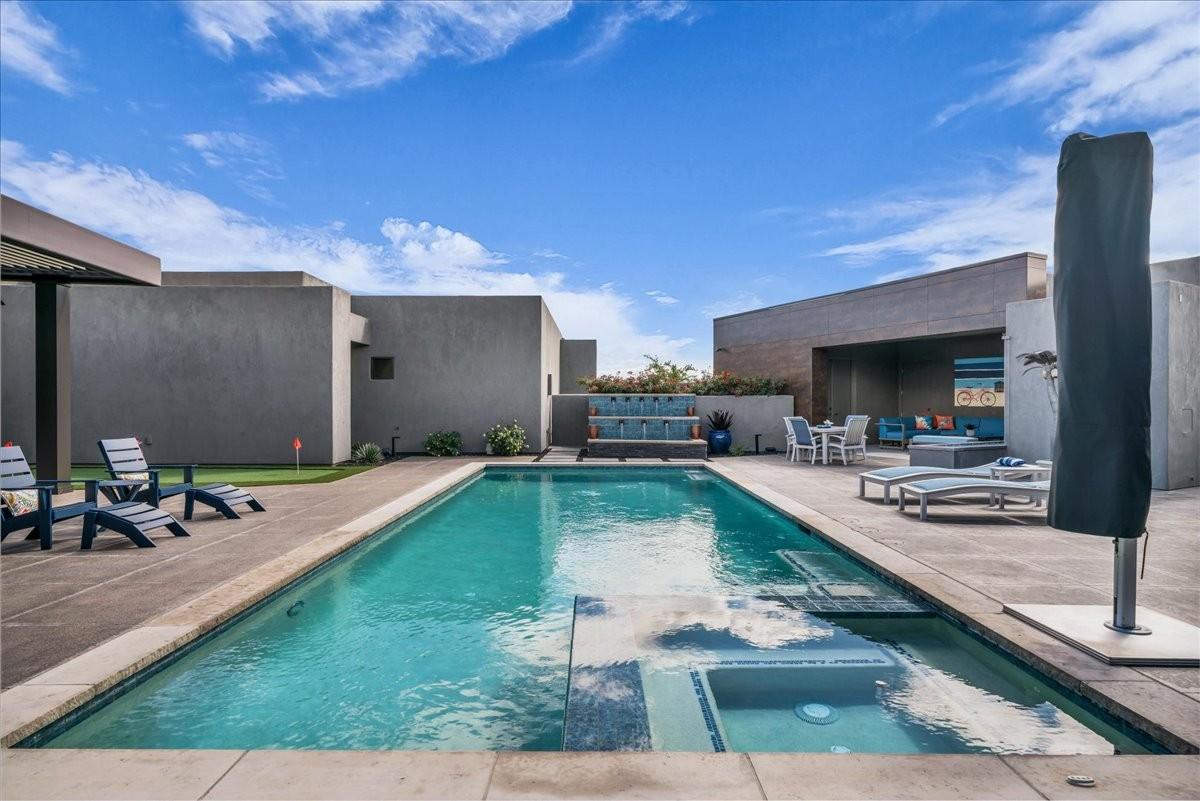 Rectangular swimming pool with integrated spa and surrounding concrete decking