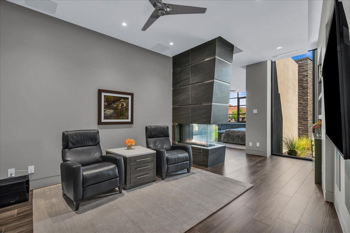 Contemporary living space featuring wood-finish flooring and a ceiling fan