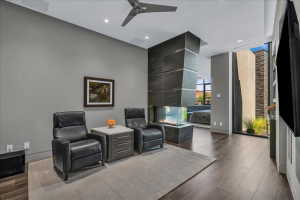 Contemporary living space featuring wood-finish flooring and a ceiling fan