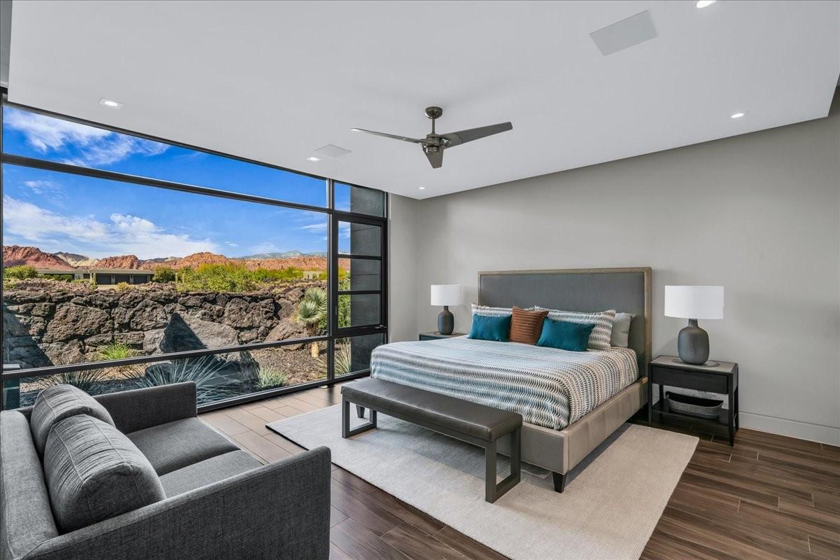 Expansive floor-to-ceiling windows with black framing showcasing desert scenery and distant mountains