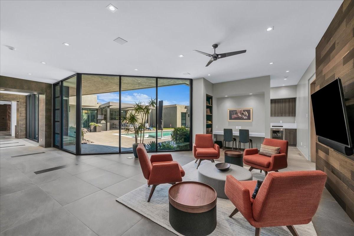 Expansive living area featuring large format tile flooring and floor-to-ceiling glass walls