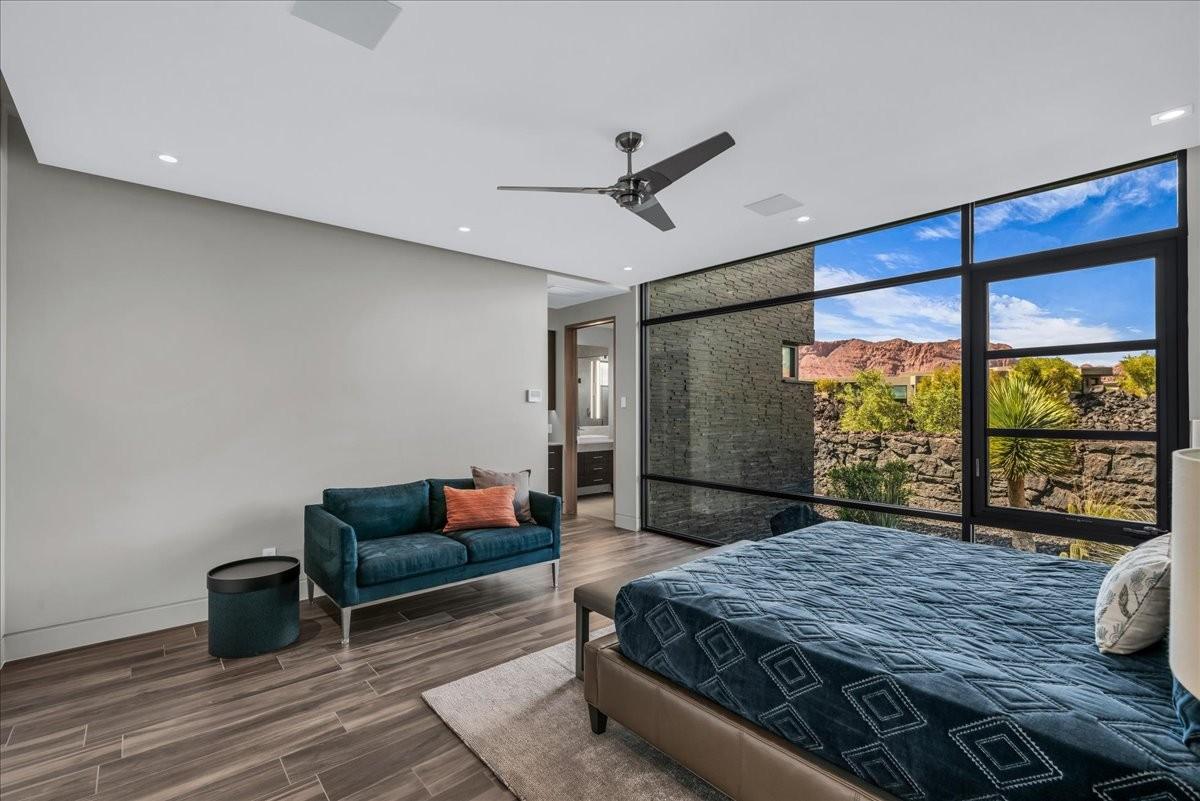 Expansive window wall with black framing, wood-finish flooring, recessed lighting, and ceiling fan