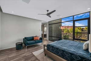 Expansive window wall with black framing, wood-finish flooring, recessed lighting, and ceiling fan