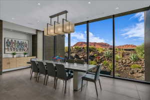 Floor-to-ceiling windows overlooking a desert landscape with red rock formations