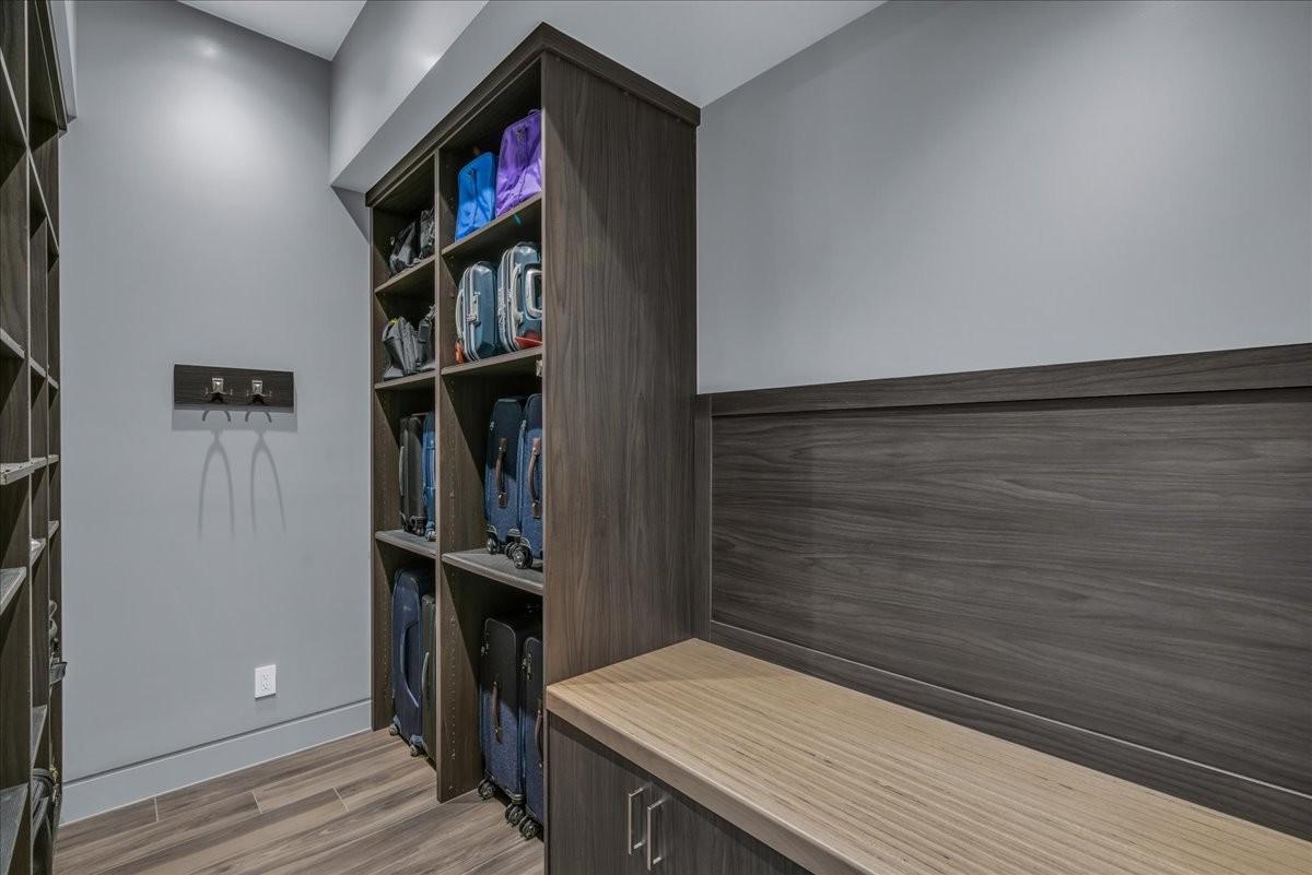 Custom built-in storage system featuring wood-finish cabinetry, open shelving, and a contrasting wood-finish benchtop
