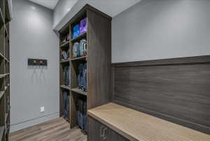 Custom built-in storage system featuring wood-finish cabinetry, open shelving, and a contrasting wood-finish benchtop
