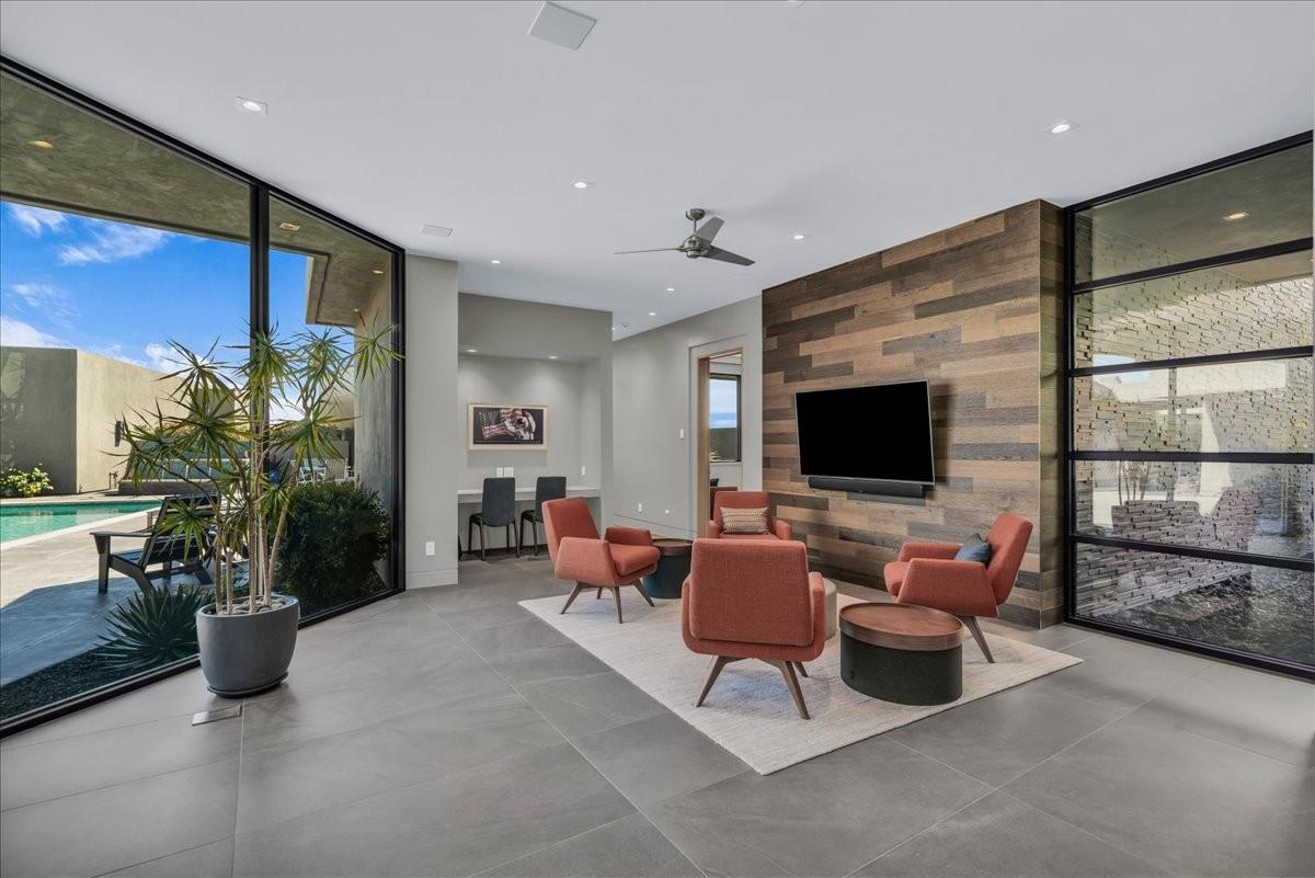 Contemporary living area featuring large format tile flooring and a wood-paneled accent wall