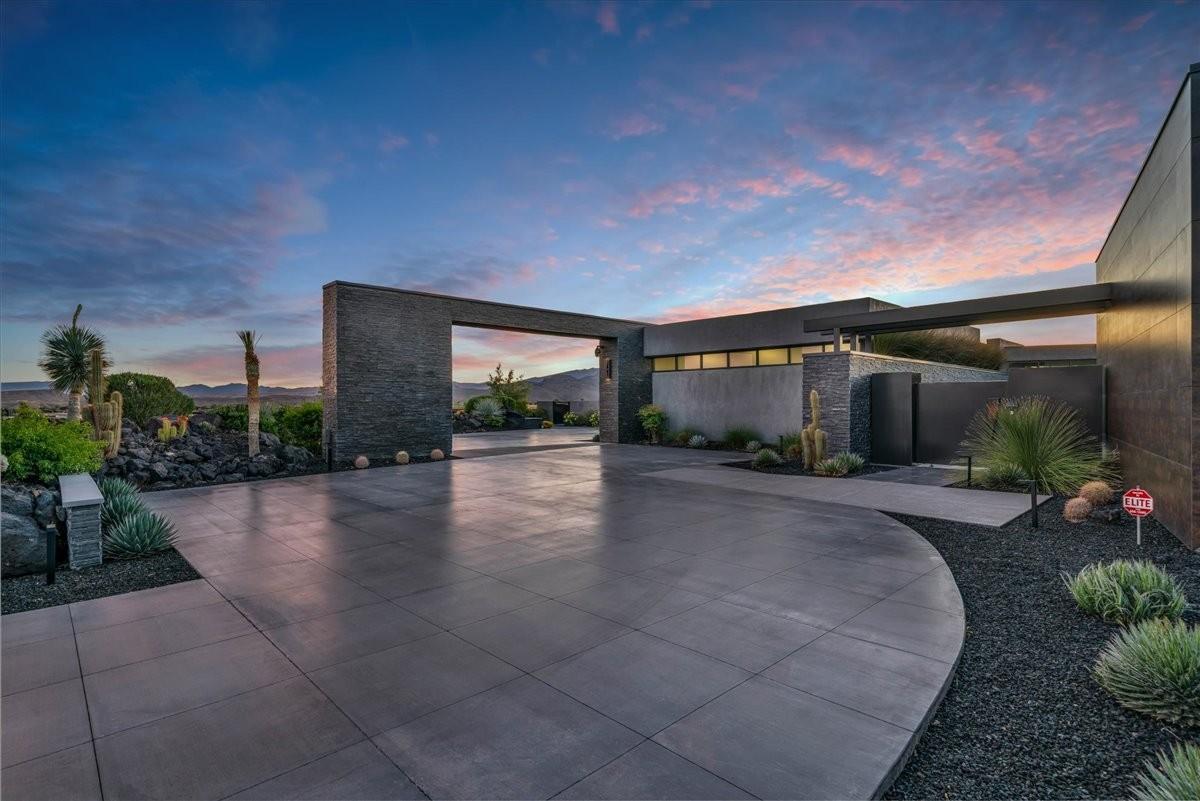 Expansive paver driveway with dark aggregate landscaping