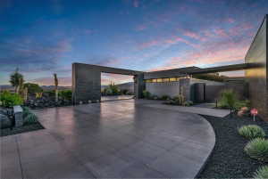Expansive paver driveway with dark aggregate landscaping