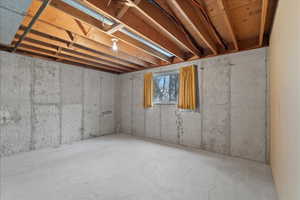 Unfinished basement featuring exposed concrete walls and flooring
