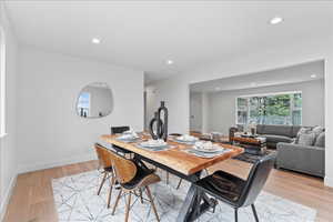 Open-concept dining area featuring light wood-finish flooring and recessed lighting