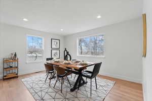 Dining area featuring light wood-finish flooring, white walls, and recessed lighting