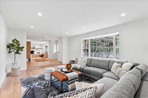 Bright living space featuring a large bay window, recessed lighting, and light wood-finish flooring