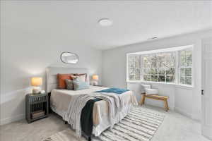 Spacious room featuring a multi-pane bay window, plush carpet flooring, recessed ceiling lighting, and crisp white walls