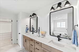 Dual vanity with wood-finish cabinetry, white countertops, and integrated sinks