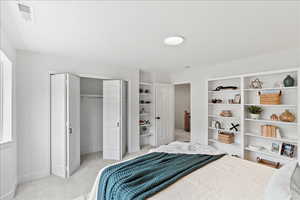 Bedroom featuring light-toned carpeting, white walls, and a recessed ceiling light