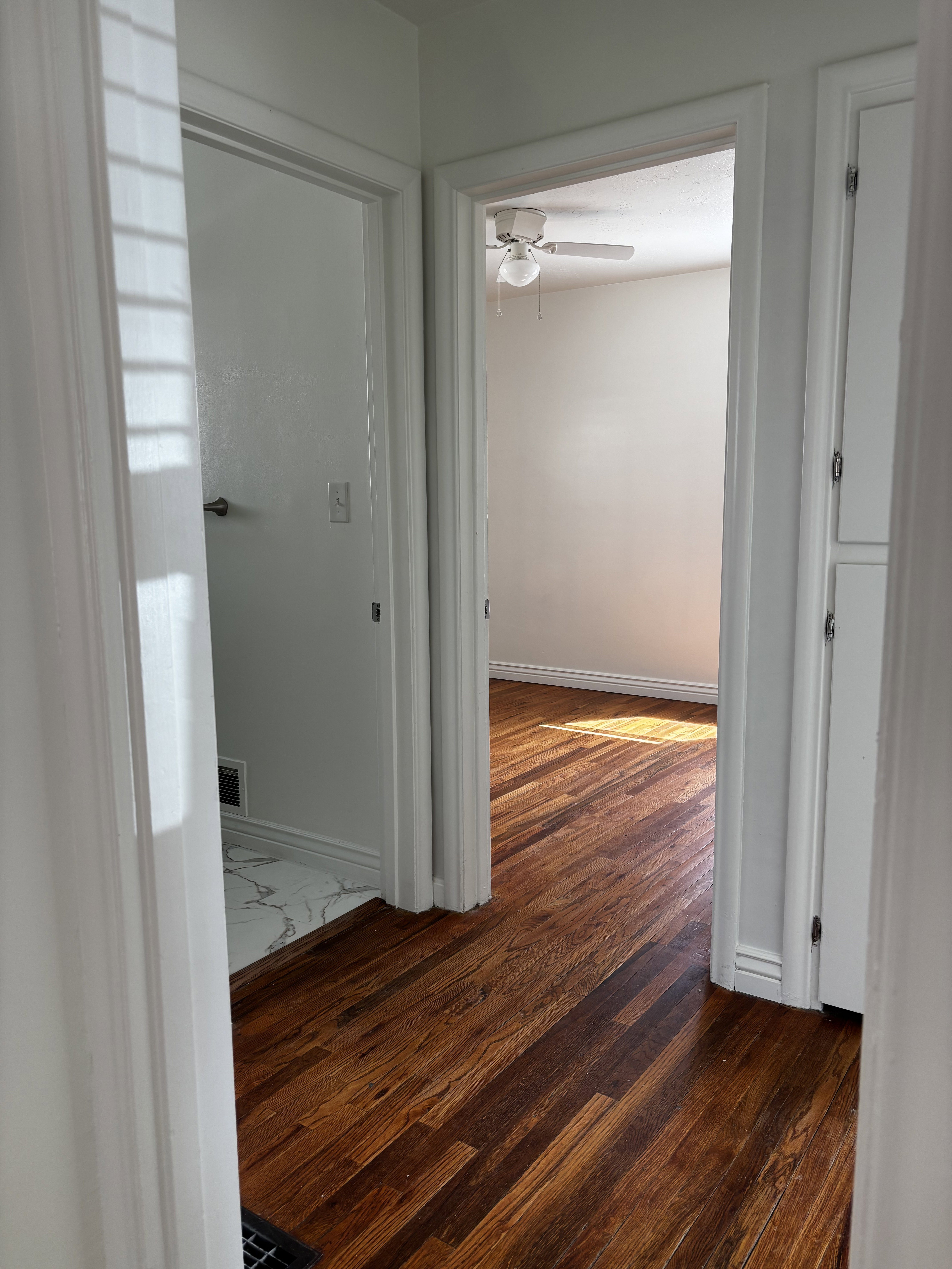 Warm wood-finish flooring extending through an interior hallway