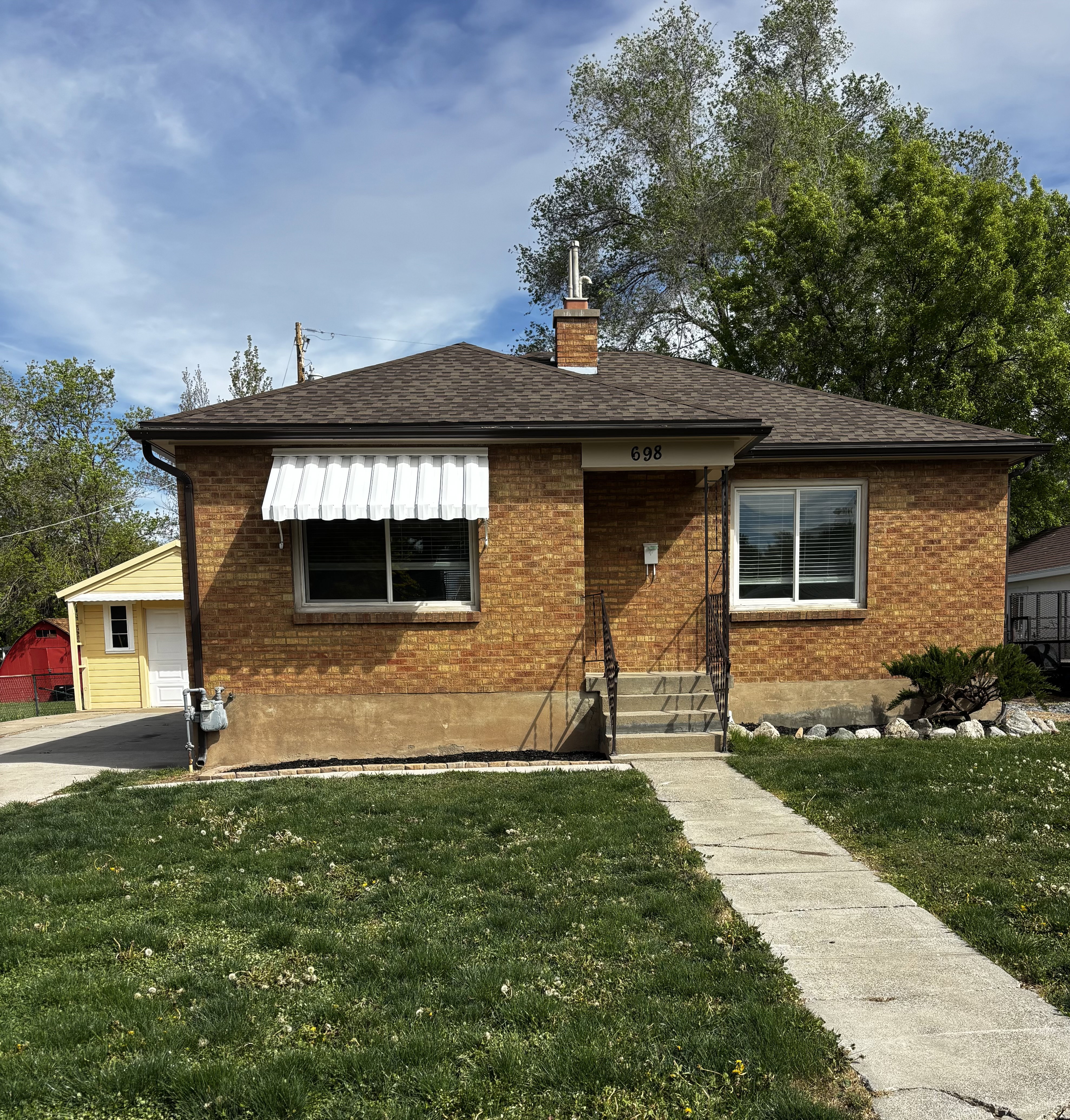 Brick exterior with a brown shingle roof