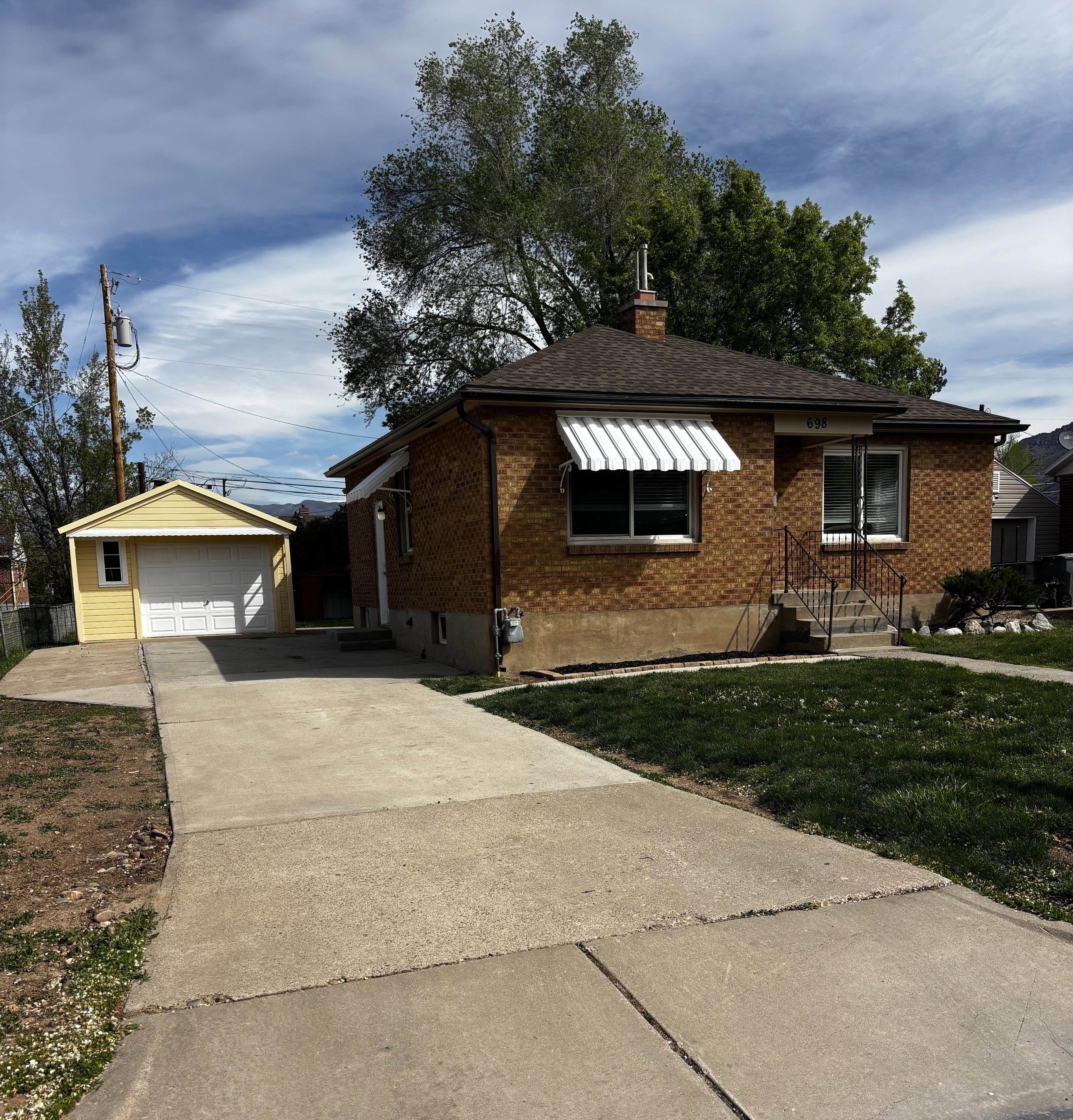 Brick exterior residence featuring a front lawn and concrete driveway