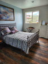 Bedroom featuring plank wood-finish flooring and a window with mountain scenery