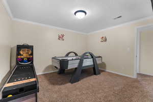 Spacious room with light neutral wall paint, white crown molding, and textured ceiling