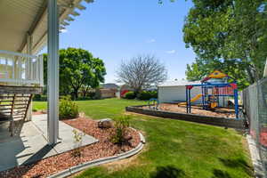 Expansive green lawn featuring a dedicated playground area with a sand base
