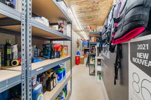 Dedicated cold storage area featuring concrete walls, exposed wood-finish ceiling, and industrial-style shelving units