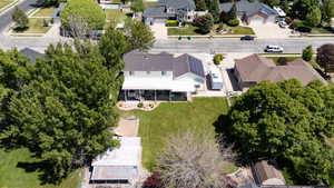 Expansive backyard featuring a manicured lawn, mature trees, and a detached outbuilding