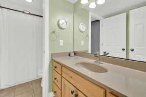 Bathroom vanity featuring a light wood-finish cabinet, integrated sink, and brushed nickel faucet