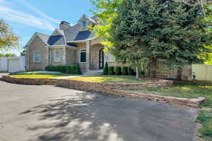 Stone-clad exterior featuring a prominent arched entryway and multiple gables