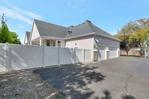 Three-car garage with stone veneer accents and a paved driveway