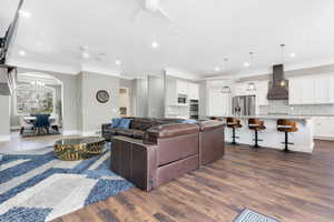 Spacious open-concept living area featuring wood-finish flooring, recessed lighting, and ceiling fans