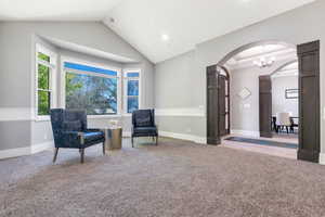 Spacious room featuring a prominent bay window, vaulted ceiling, and recessed lighting