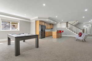 Spacious lower level featuring a wet bar with wood-finish cabinetry, stainless steel refrigerator, and recessed lighting