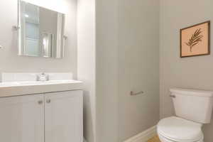 White vanity with integrated sink, chrome faucet, and rectangular wall-mounted mirror