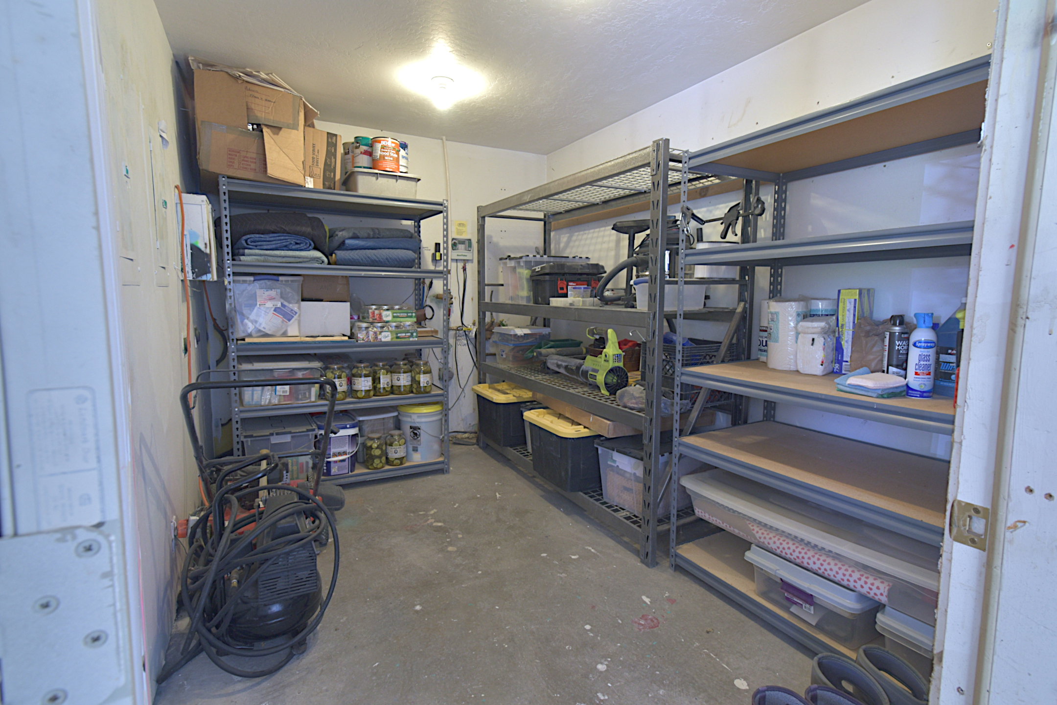 Dedicated storage area featuring concrete flooring and built-in metal shelving units