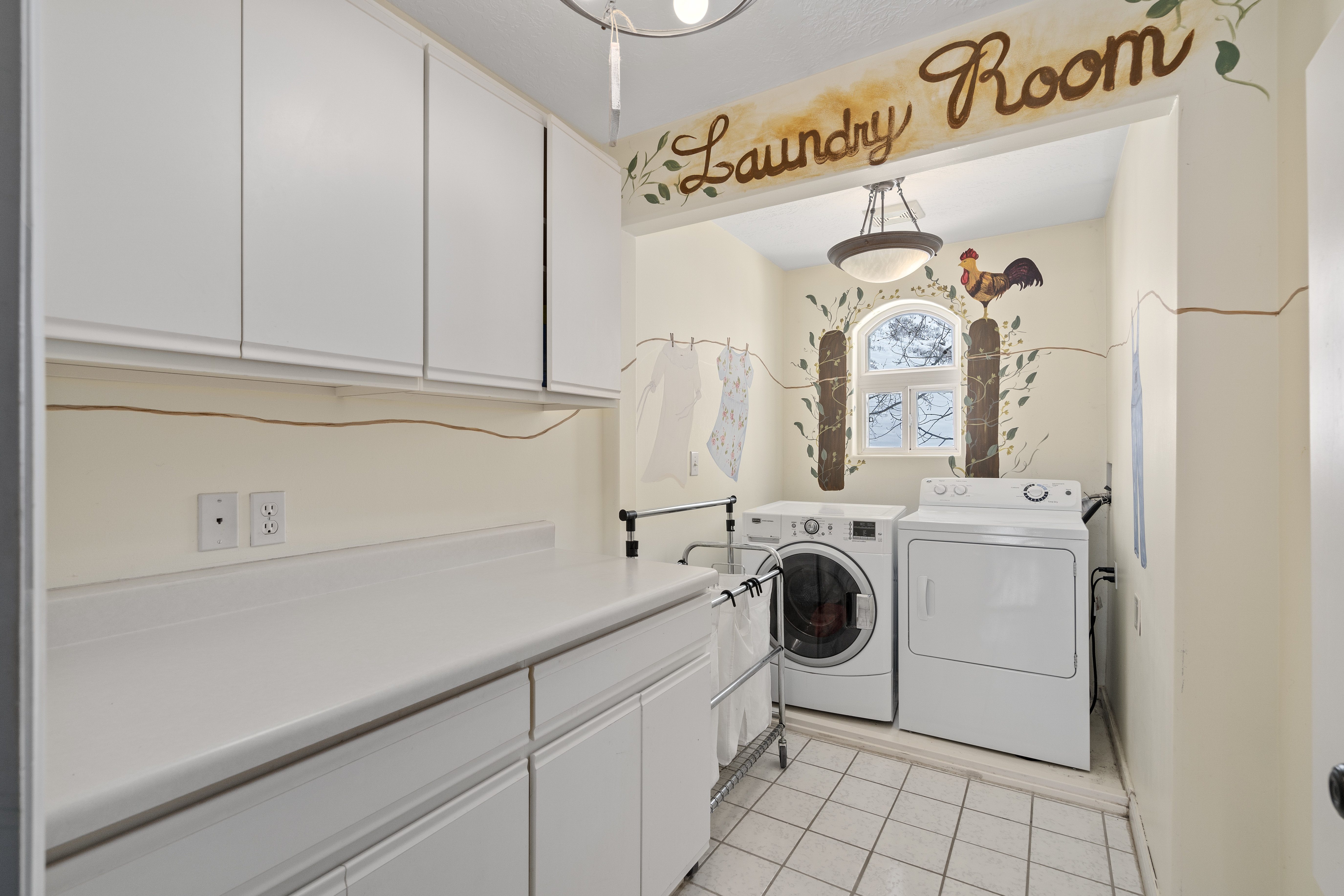 Dedicated laundry room featuring white cabinetry, a spacious countertop, and tile flooring
