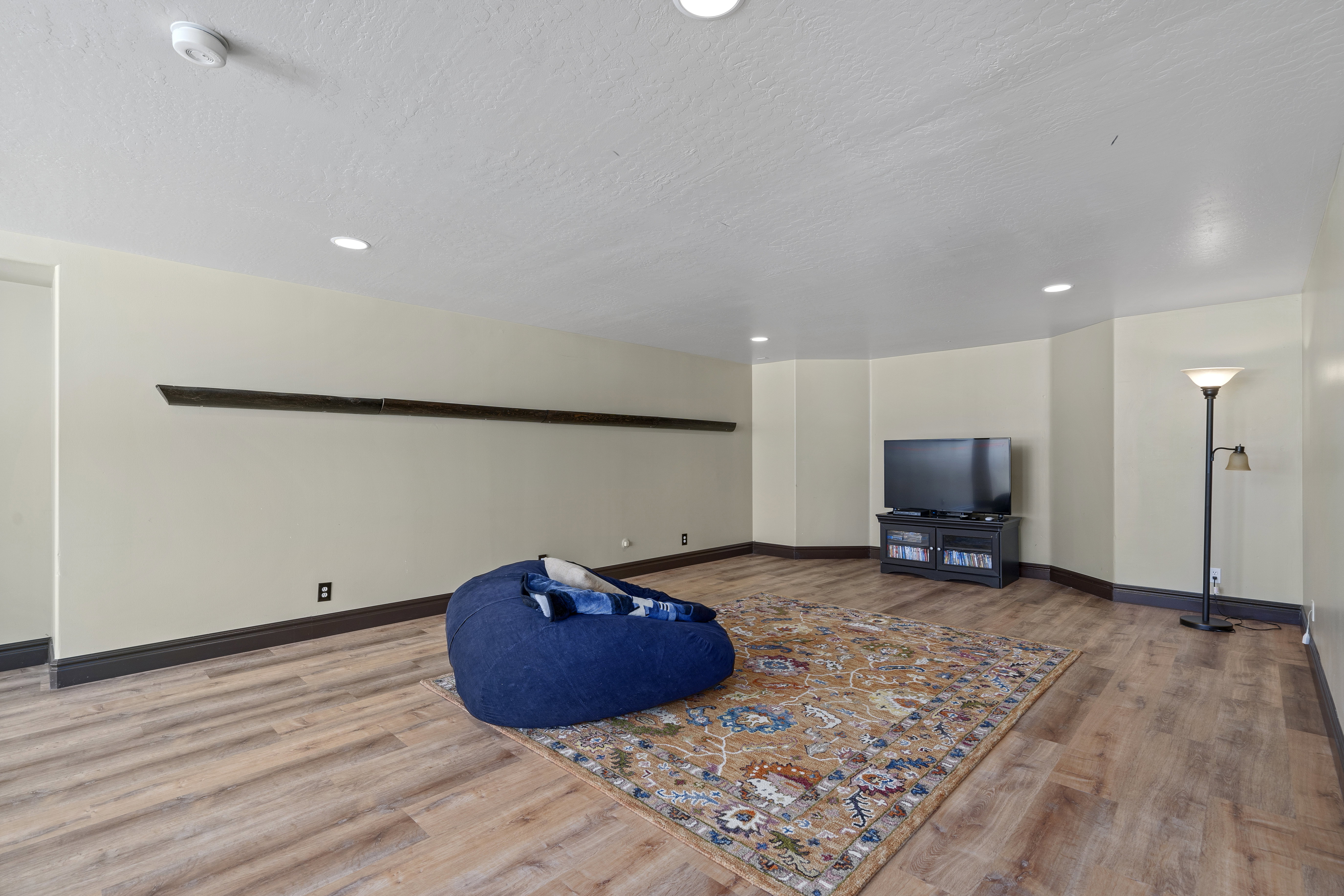 Spacious room featuring wood-finish flooring, recessed lighting, and light-toned walls