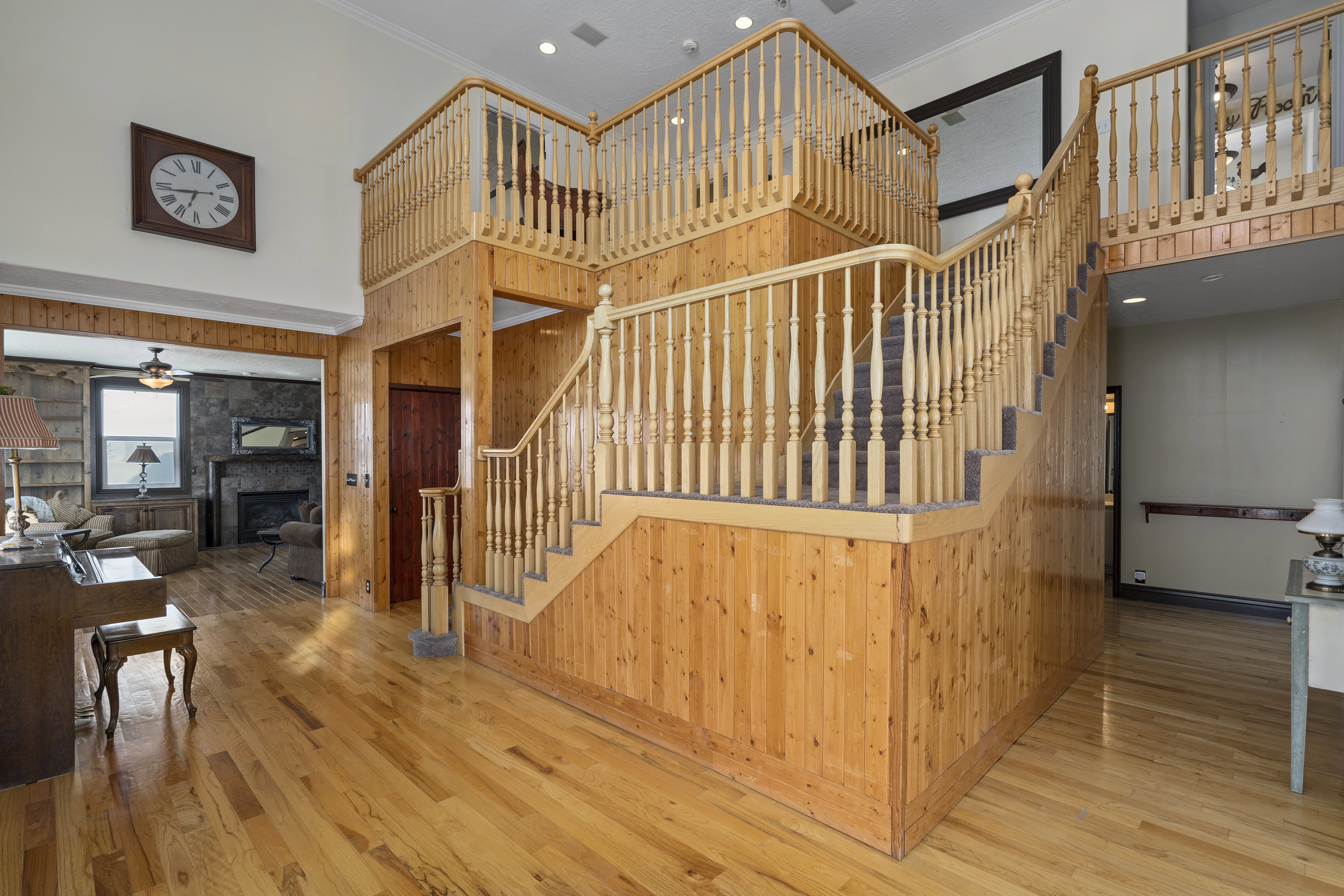 Two-story entry featuring extensive wood-paneled walls and matching wood-finish flooring