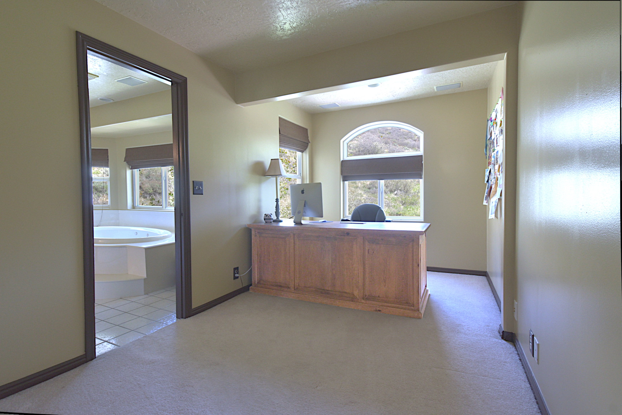 Carpeted room with an arched window, recessed lighting, and a wood-finish desk