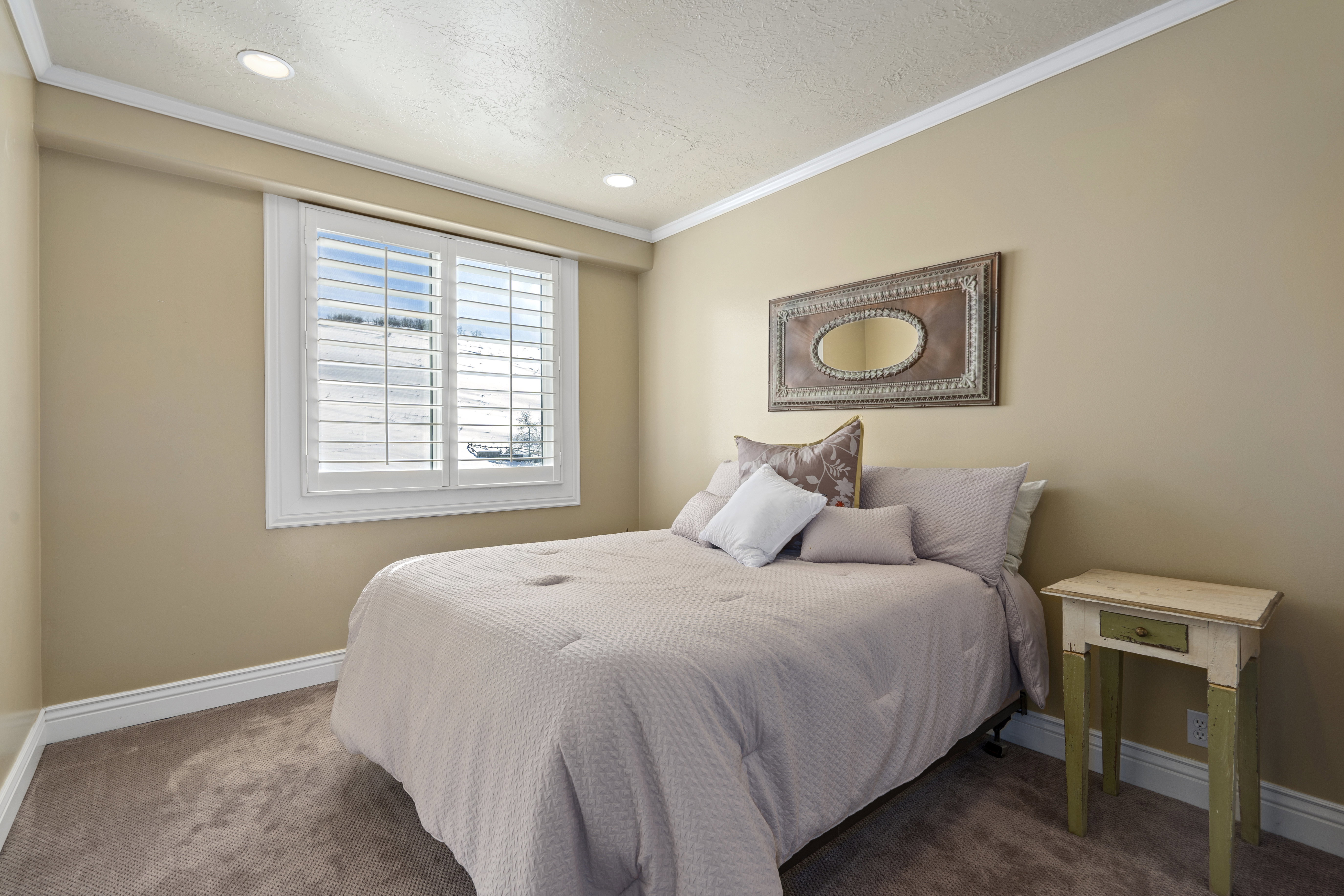 Room featuring recessed lighting, a window with white plantation shutters, neutral-toned walls, crown molding, and carpeting