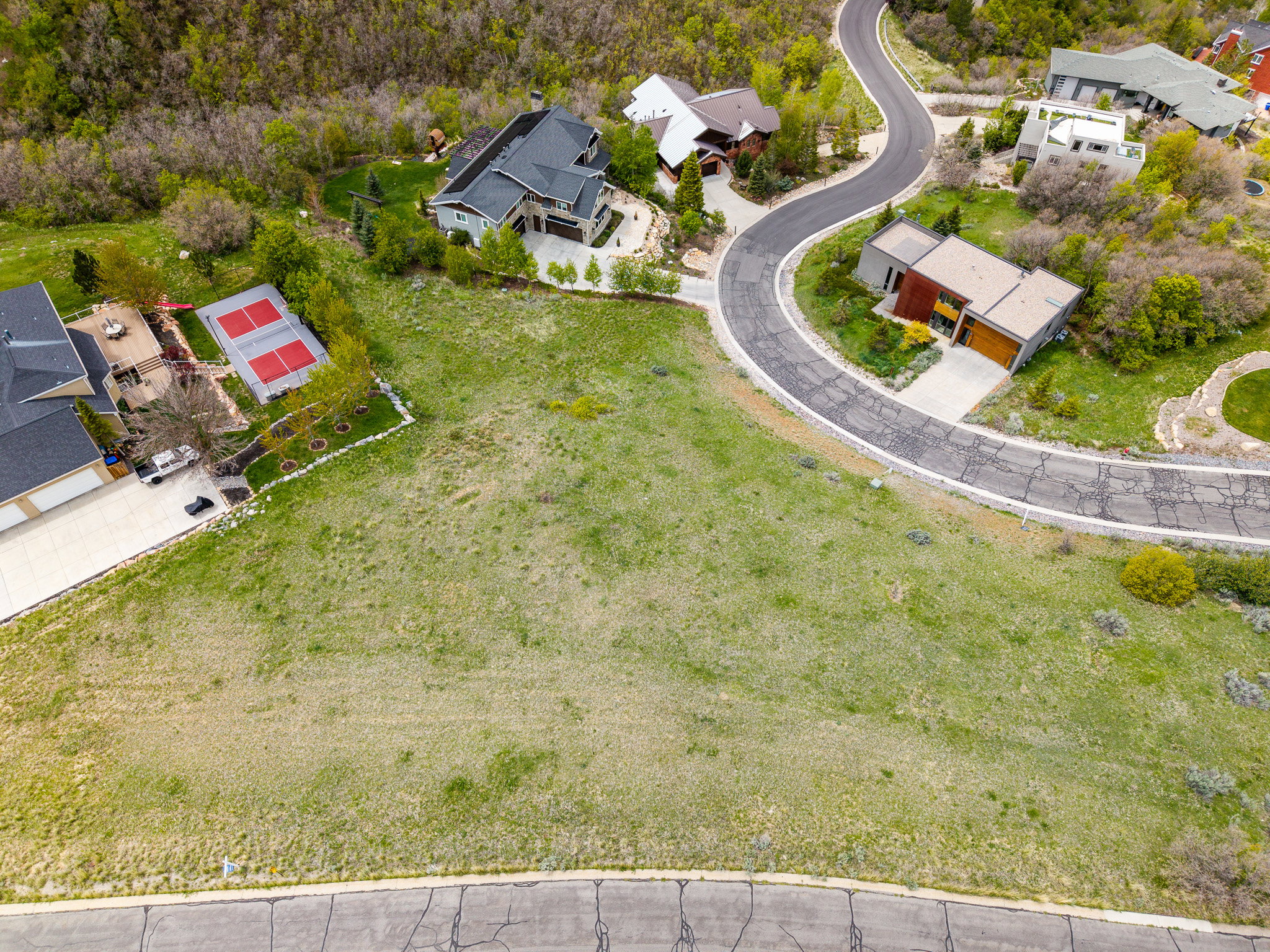 Expansive grassy lot featuring a gentle slope