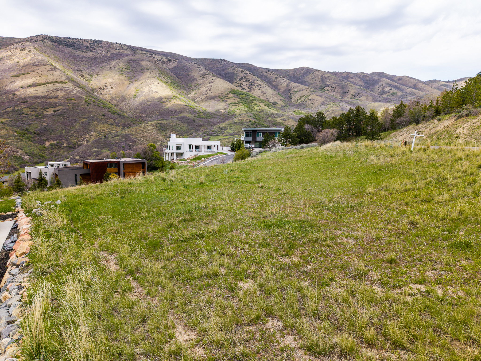 Expansive undeveloped lot featuring natural grass and a gently sloping terrain, framed by distant mountains
