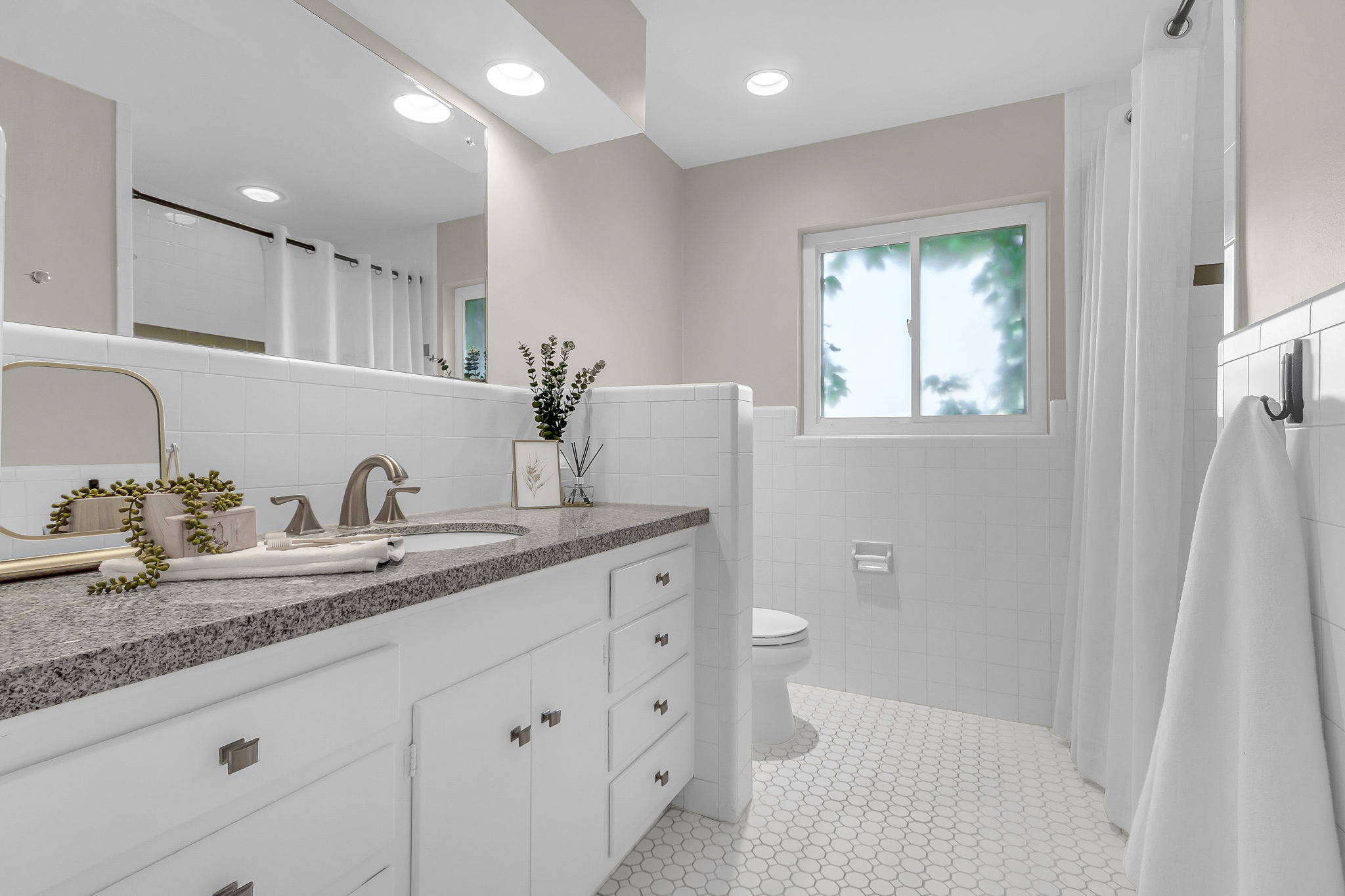 Bathroom featuring a white vanity with a dark speckled countertop, undermount sink, and brushed nickel faucet