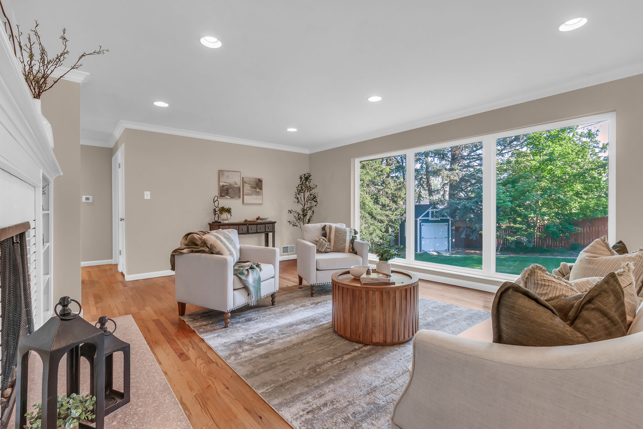 Spacious living area featuring expansive windows overlooking a green backyard