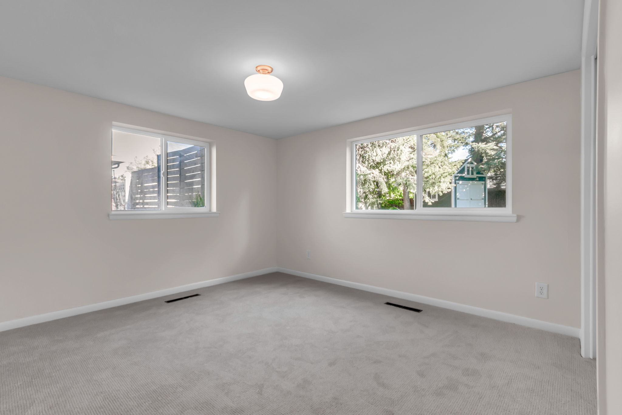 Neutral-toned walls complement the light gray carpet flooring